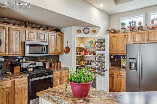 kitchen with tasteful backsplash and appliances with stainless steel finishes