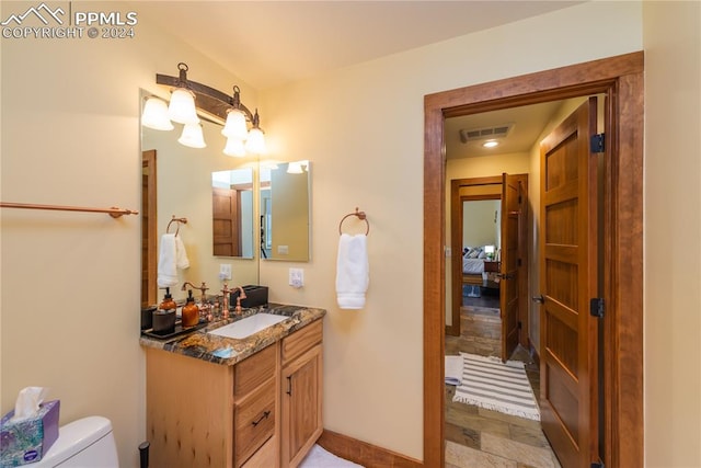 bathroom featuring toilet, large vanity, and tile floors