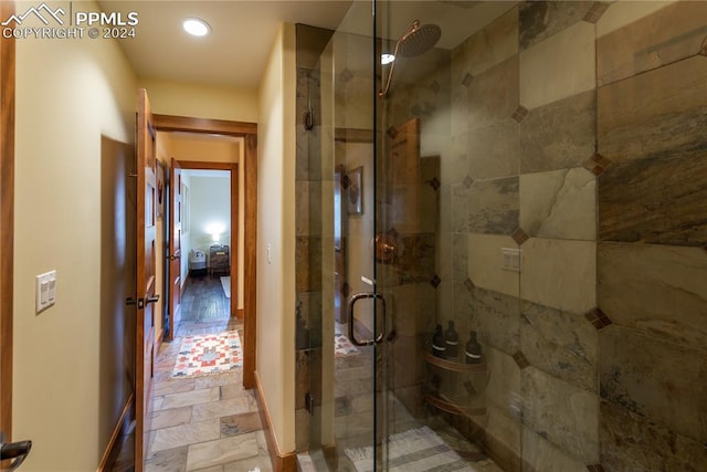 bathroom with tile flooring and a shower with shower door