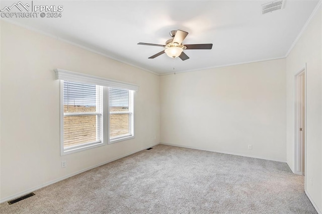 empty room with ceiling fan, ornamental molding, and light carpet