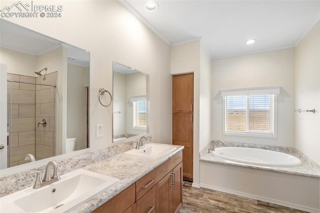 bathroom featuring hardwood / wood-style floors, double sink vanity, a bath to relax in, toilet, and crown molding