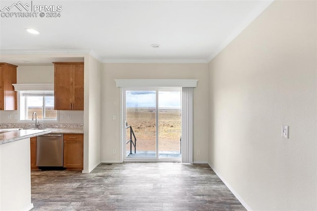 kitchen with ornamental molding, dishwasher, sink, and light wood-type flooring