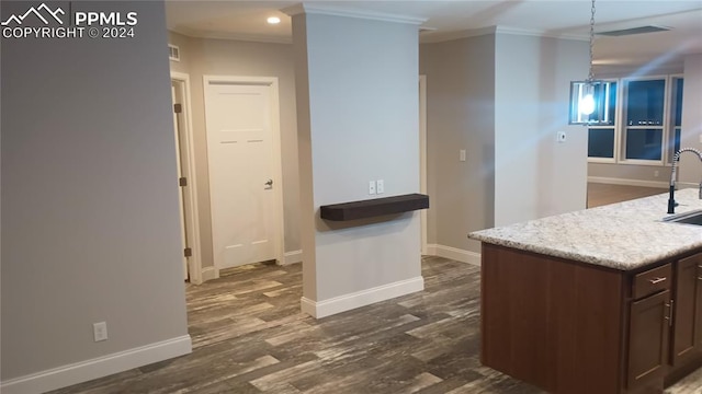 kitchen with dark brown cabinets, crown molding, sink, dark hardwood / wood-style floors, and hanging light fixtures