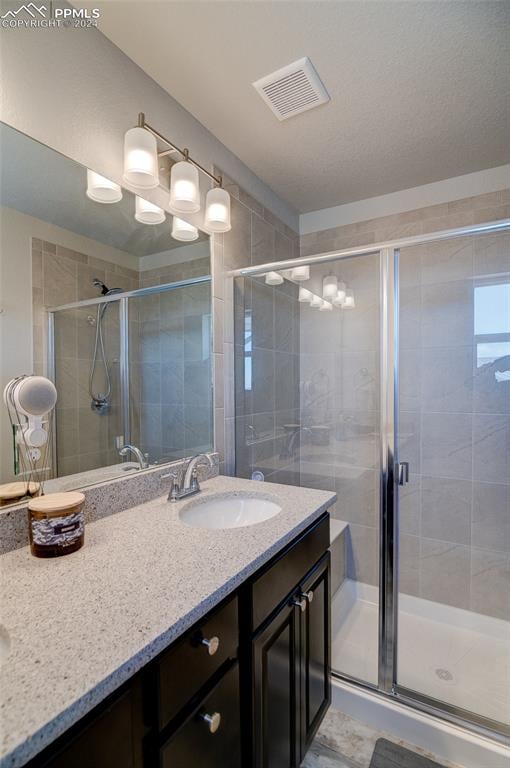 bathroom with vanity, an enclosed shower, and tile floors