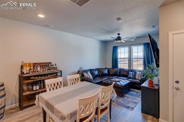 dining area featuring ceiling fan, a textured ceiling, and light hardwood / wood-style floors