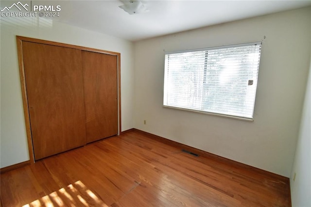 unfurnished bedroom with light hardwood / wood-style floors and a closet