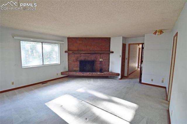 unfurnished living room with a textured ceiling, brick wall, light carpet, and a large fireplace