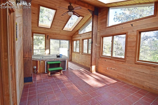 unfurnished sunroom featuring wooden ceiling, vaulted ceiling with skylight, and ceiling fan