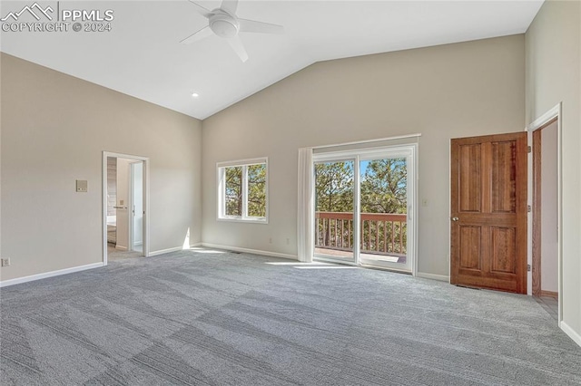 carpeted empty room with high vaulted ceiling and ceiling fan