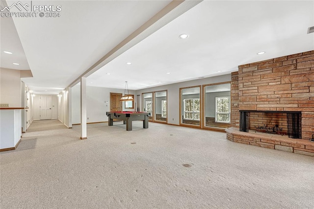 unfurnished living room with pool table, light carpet, and a stone fireplace