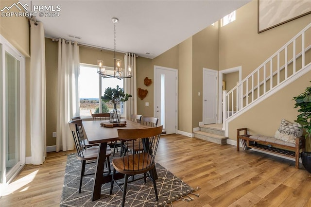 dining area with light wood-type flooring and a chandelier