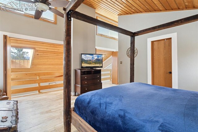 bedroom featuring wood walls, light hardwood / wood-style flooring, ceiling fan, and wooden ceiling