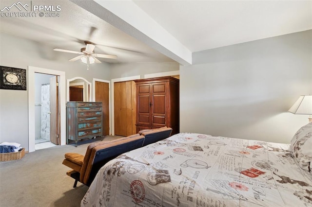 carpeted bedroom with ensuite bath, beam ceiling, and ceiling fan