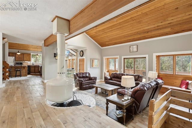 living room featuring vaulted ceiling, light hardwood / wood-style flooring, and ornate columns