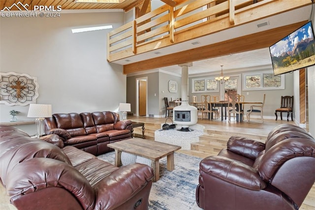 living room featuring high vaulted ceiling, light hardwood / wood-style floors, decorative columns, and an inviting chandelier