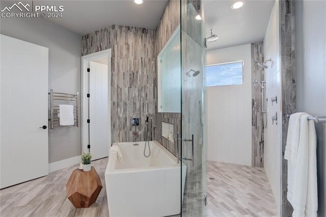 bathroom with shower with separate bathtub and radiator heating unit