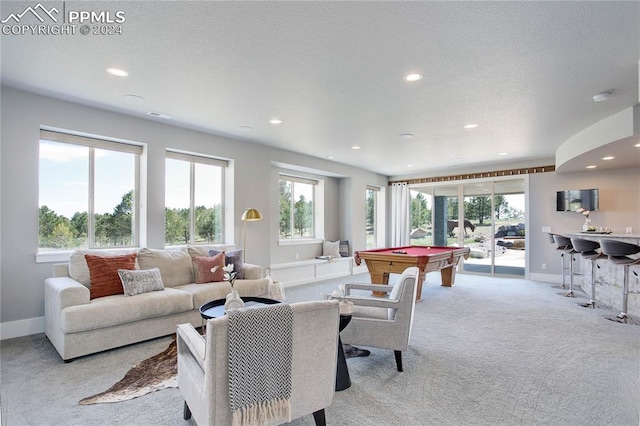 living room featuring light colored carpet, plenty of natural light, and billiards