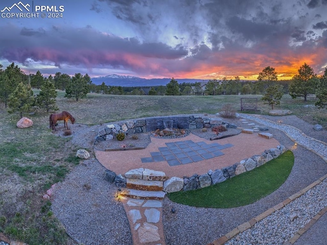 yard at dusk featuring a patio and an outdoor fire pit