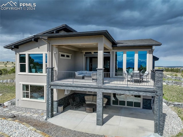 rear view of house featuring a balcony and a patio area