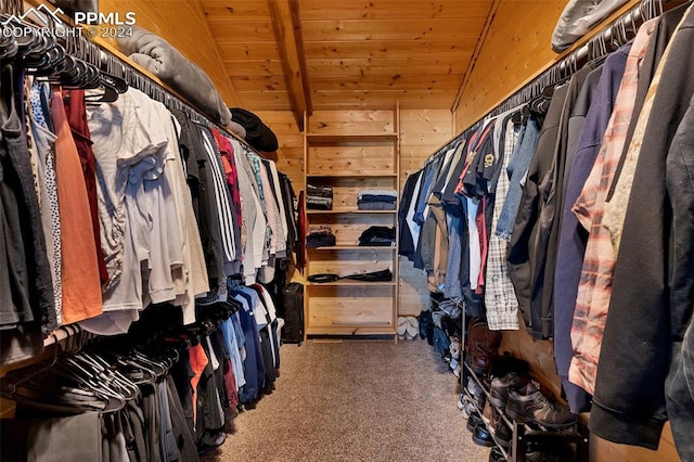 walk in closet with dark carpet and lofted ceiling