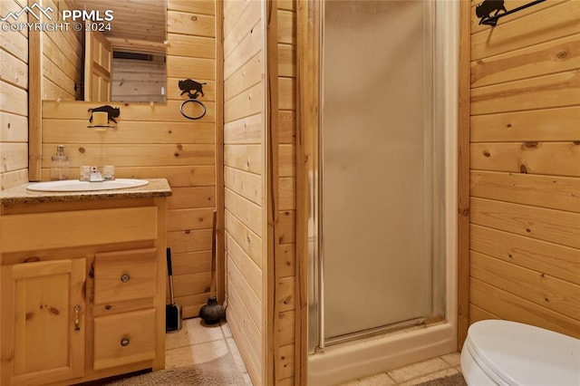 bathroom with an enclosed shower, vanity, toilet, and tile floors