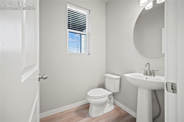 bathroom with toilet and hardwood / wood-style flooring