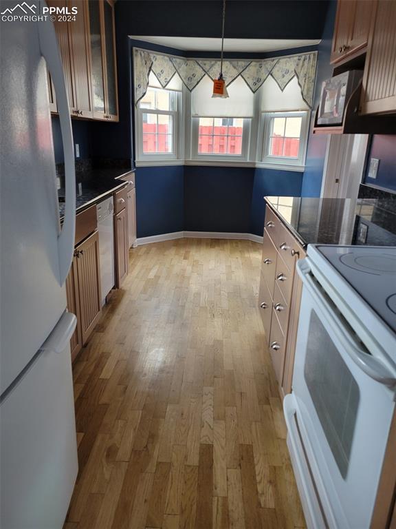 kitchen featuring white appliances, light wood-type flooring, and pendant lighting