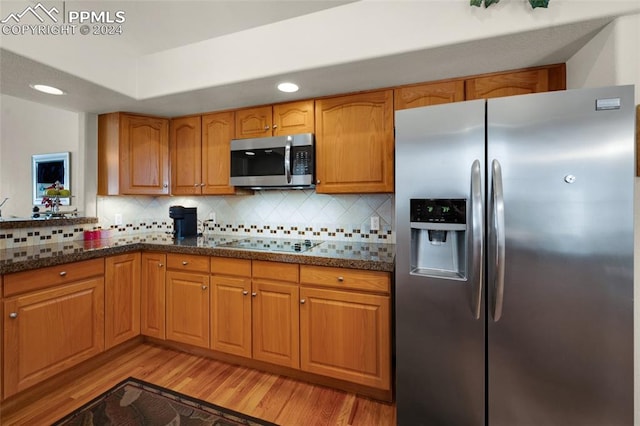 4529 Songglen Cir, Colorado Springs, CO 80906 - kitchen featuring backsplash, stainless steel appliances, light hardwood / wood-style floors, and dark stone countertops