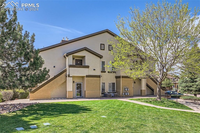 view of front of property featuring a front yard and a balcony