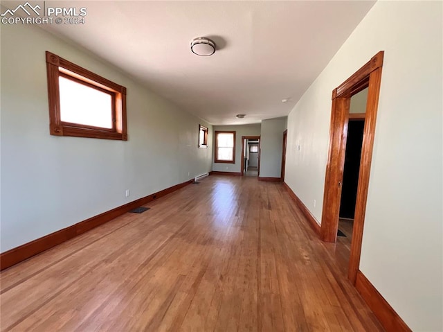 corridor featuring a baseboard radiator and hardwood / wood-style floors