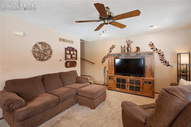 living room with ceiling fan with notable chandelier, light tile floors, and a textured ceiling