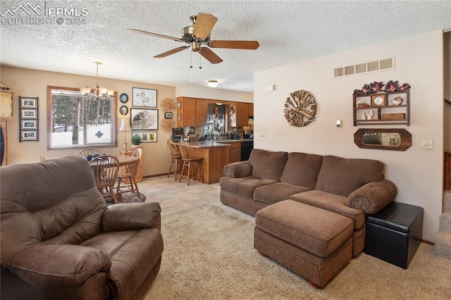 kitchen featuring gas stove, a textured ceiling, sink, black dishwasher, and pendant lighting