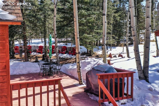 view of snowy exterior with an outdoor structure and a garage