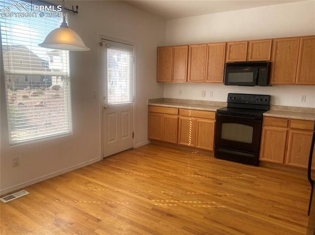 kitchen featuring light hardwood / wood-style flooring, pendant lighting, and black appliances