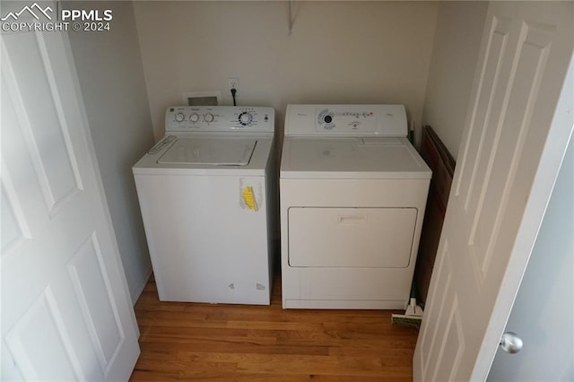 laundry room featuring separate washer and dryer and light hardwood / wood-style floors