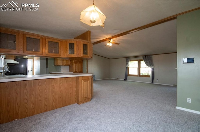 kitchen featuring kitchen peninsula, light colored carpet, hanging light fixtures, sink, and vaulted ceiling