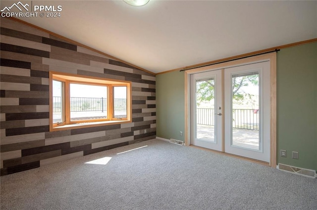 spare room with ornamental molding, french doors, vaulted ceiling, and carpet flooring