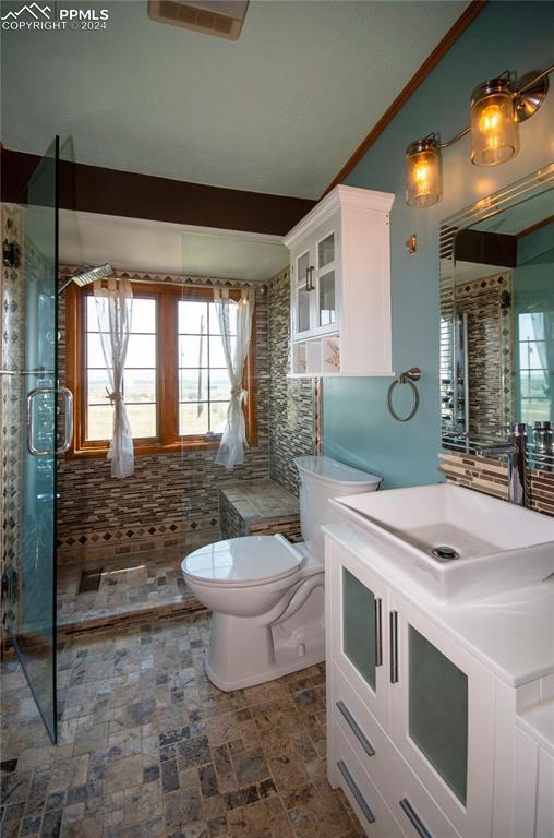 bathroom featuring toilet, lofted ceiling, an enclosed shower, crown molding, and vanity