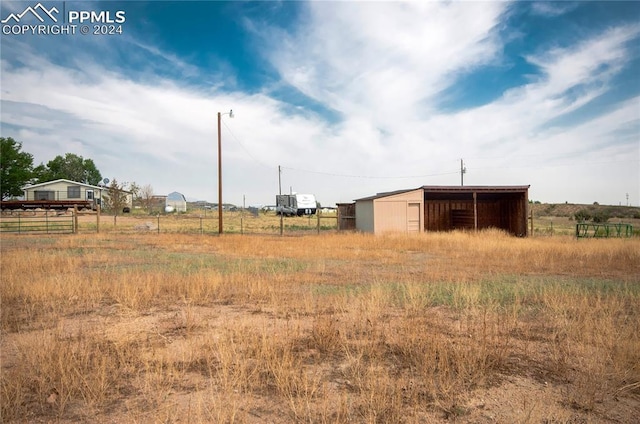 view of yard with a rural view and an outdoor structure