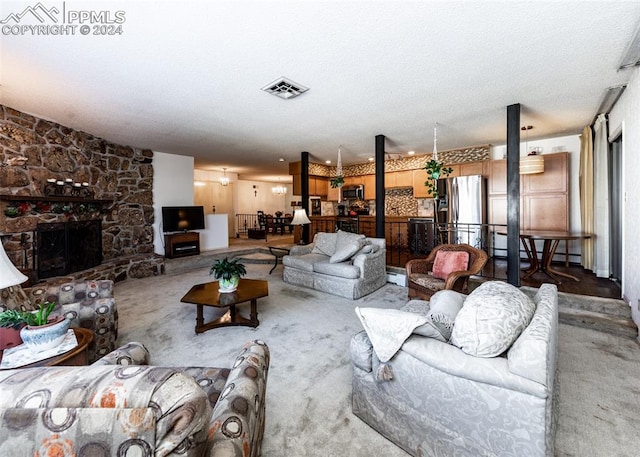 living room featuring a stone fireplace, a textured ceiling, and carpet floors