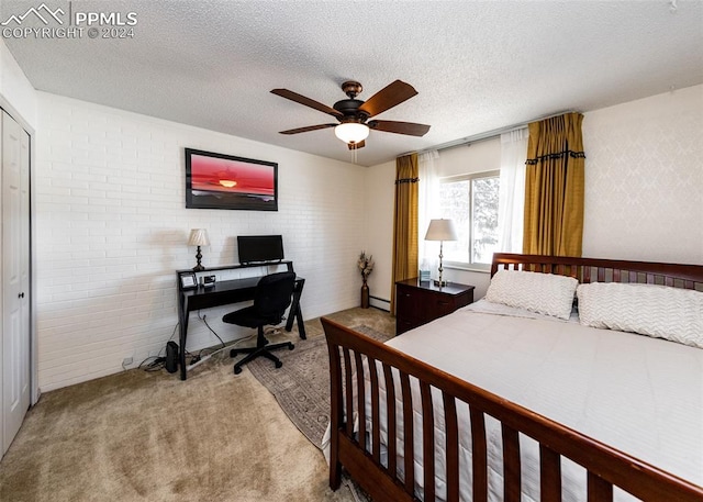 bedroom featuring a closet, ceiling fan, a textured ceiling, light carpet, and brick wall