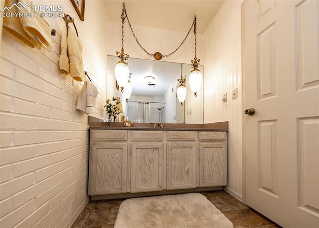 bathroom featuring vanity, brick wall, and tile flooring