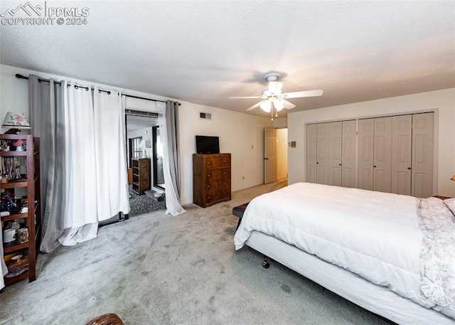 carpeted bedroom with a closet, ceiling fan, and a textured ceiling