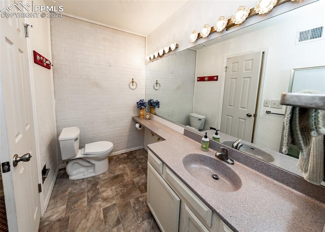 bathroom featuring tile floors, vanity, toilet, and tile walls