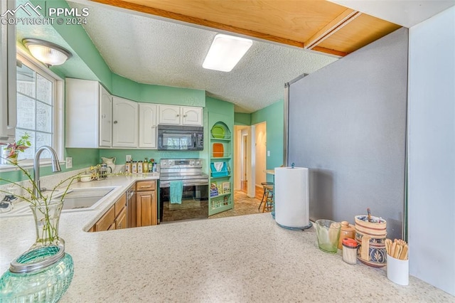 kitchen with kitchen peninsula, a textured ceiling, sink, black appliances, and white cabinetry