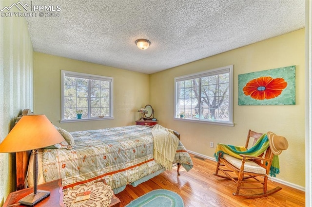 bedroom featuring wood-type flooring and a textured ceiling