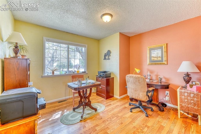 office space with a textured ceiling and light hardwood / wood-style floors