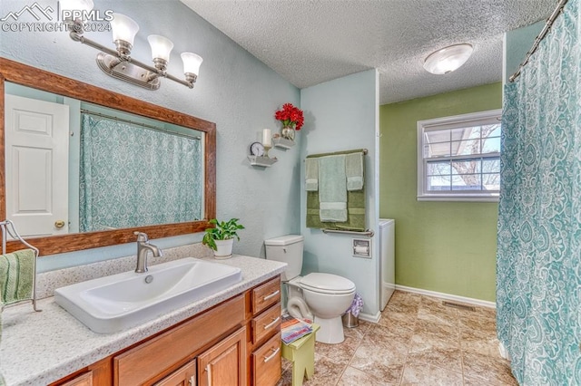 bathroom featuring vanity, a textured ceiling, and toilet