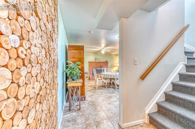 interior space featuring ceiling fan and a brick fireplace