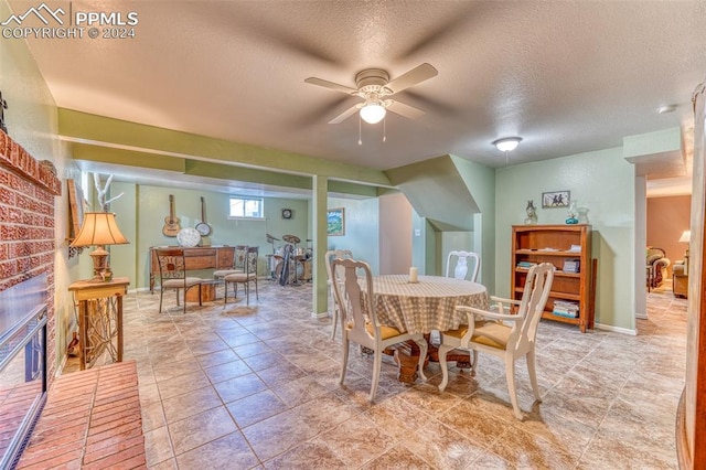 dining area featuring ceiling fan and a textured ceiling